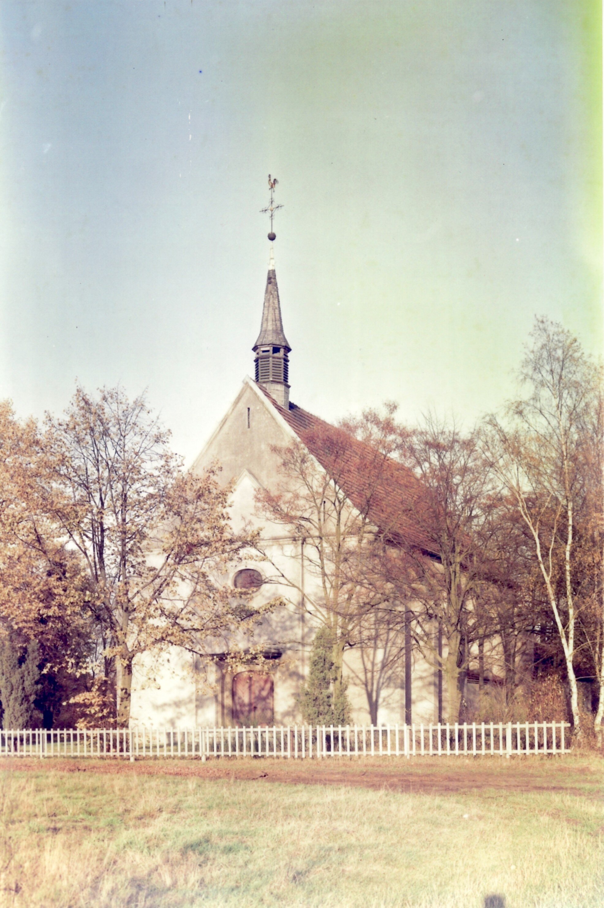 Ein Blick auf die Hövelsenner Kirche unter blauem Himmel, umgeben von kahlen Bäumen.