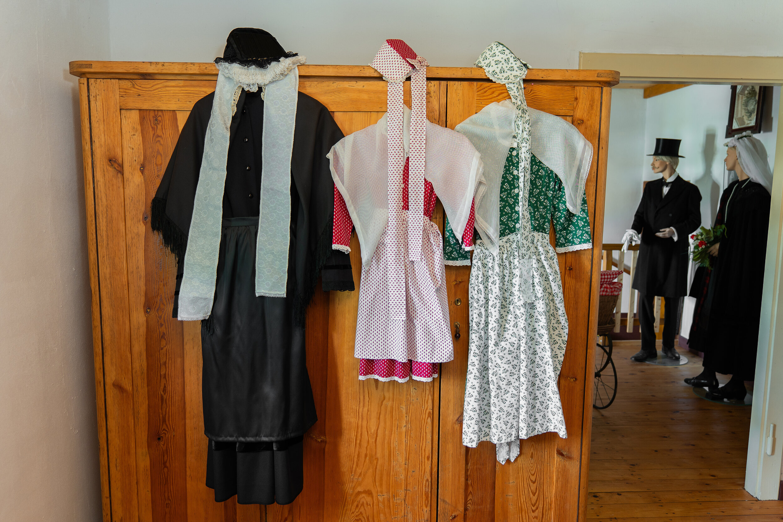 Zu sehen sind die traditionellen Trachten der historischen Senne. Für die jungen Mädchen kürzere Kleider mit rot und grün als Schmuckfarbe, für ältere , verheiratete Frauen die schwarze, lange Tracht.